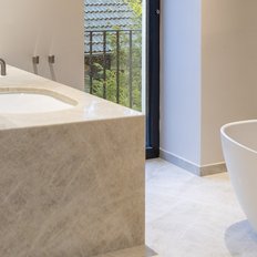 Ein modernes Badezimmer mit einer freistehenden Badewanne und eleganten, hellen Fliesen, die eine entspannende Atmosphäre schaffen.