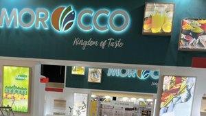 Ein lebendiger Stand mit dem Schriftzug 'MOROCCO' und bunten Bildern von Speisen und Getränken, die den Geschmack Marokkos repräsentieren.