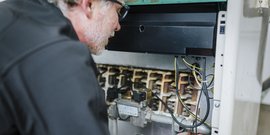 Ein Techniker untersucht sorgfältig die elektrischen Komponenten eines Geräts, um mögliche Probleme zu identifizieren.