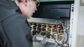 Ein Techniker untersucht sorgfältig die elektrischen Komponenten eines Geräts, um mögliche Probleme zu identifizieren.