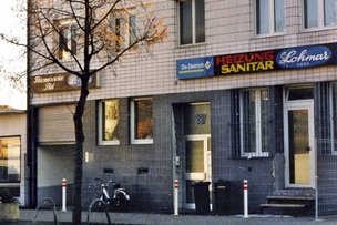 Das Geschäft hat eine graue Wandfarbe und eine Eingangstür mit einem kleinen Treppenaufgang.