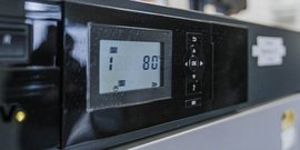 Ein digitales Display zeigt die Temperatur von 80 Grad und die Stufe 1 auf einem modernen Küchengerät.