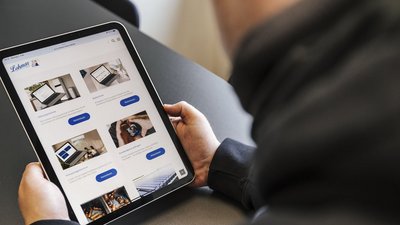 Auf dem Bildschirm des Tablets sind mehrere Bilder von Heizungs- und Klimaanlagen sowie Informationen zu Dienstleistungen zu sehen.