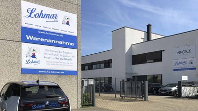 Im Vordergrund steht ein BMW-Fahrzeug, während im Hintergrund die hellen Wände des Lohmar-Gebäudes sichtbar sind.