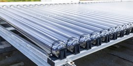 Eine Reihe von transparenten Röhren auf einem Metallgestell, die für die Nutzung von Sonnenenergie konzipiert sind.
