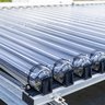 Moderne Solarthermie-Röhren auf einem Dach installiert Eine Reihe von transparenten Röhren auf einem Metallgestell, die für die Nutzung von Sonnenenergie konzipiert sind.