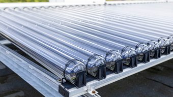 Moderne Solarthermie-Röhren auf einem Dach installiert Eine Reihe von transparenten Röhren auf einem Metallgestell, die für die Nutzung von Sonnenenergie konzipiert sind.