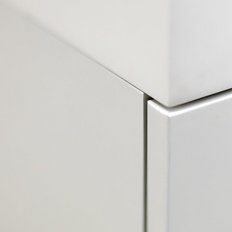 Die Nahaufnahme zeigt die Kante eines modernen, weißen Möbelstücks mit klaren Linien und minimalistischer Ästhetik.