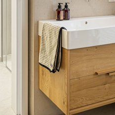 Ein modernes Badezimmer mit einem eleganten Waschbecken aus Keramik und einem Holzschrank, der stilvoll gestaltet ist.