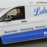 Lohmar GmbH: Meisterbetrieb für Sanitär und Elektro Ein Lieferwagen mit dem Logo von Lohmar steht auf einem Parkplatz, während der Fahrer bereit ist, seine nächste Aufgabe zu beginnen.