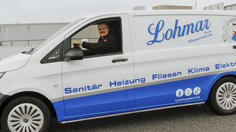 Lohmar GmbH: Meisterbetrieb für Sanitär und Elektro Ein Lieferwagen mit dem Logo von Lohmar steht auf einem Parkplatz, während der Fahrer bereit ist, seine nächste Aufgabe zu beginnen.