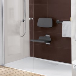 Ein modernes Badezimmer mit einer barrierefreien Dusche, ausgestattet mit einem Haltegriff und einem Sitzplatz für mehr Komfort.