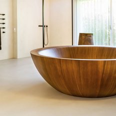 Ein elegantes Badezimmer mit einer großen, runden Holzbadewanne und modernen Armaturen, die ein Gefühl von Luxus vermitteln.