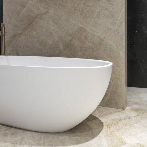 Ein elegantes, freistehendes Badewanne in einem modernen Badezimmer mit stilvollen, hellen Fliesen und einer dunklen Wand.