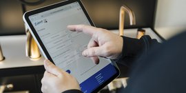 Der Benutzer tippt auf einem Tablet, um verschiedene Optionen für Immobilien zu filtern, um die beste Wahl zu treffen.