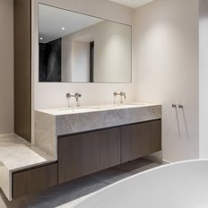Ein modernes Badezimmer mit einem eleganten Doppelwaschbecken und einem großen Spiegel, der den Raum hell erleuchtet.